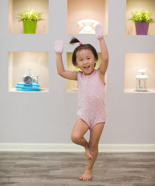 baby girl posing ballerina wearing pink GOTS certified organic cotton bodysuit and mittens designed for eczema