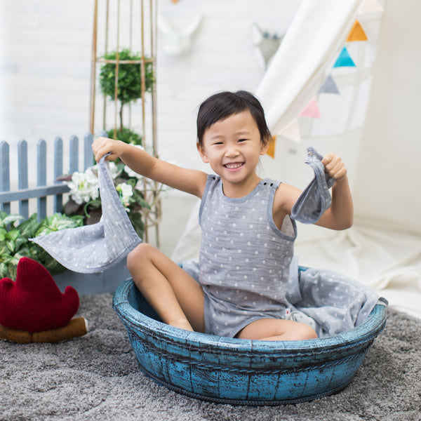 Toddler girl playing with charcoal gray GOTS Certified Organic Cotton baby hanky wearing Pokka Kids bodysuit