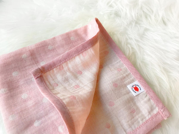 Folded pink GOTS certified organic cotton hanky for use as a wash cloth, burp cloth, bib, scarf or security blanket